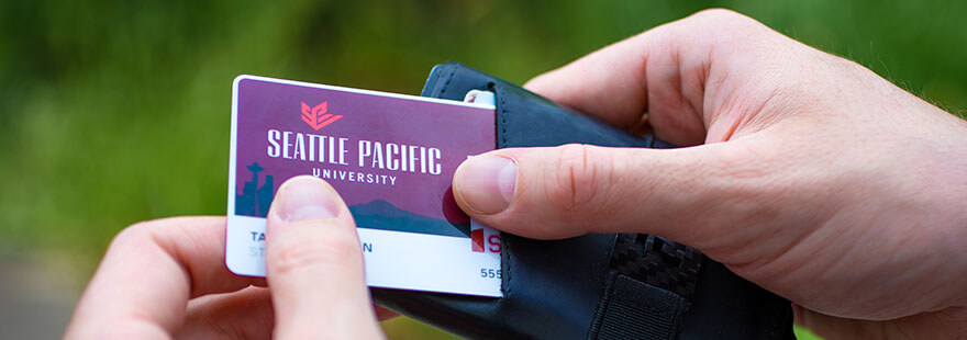 Two hands pulling a Falcon card out of a wallet